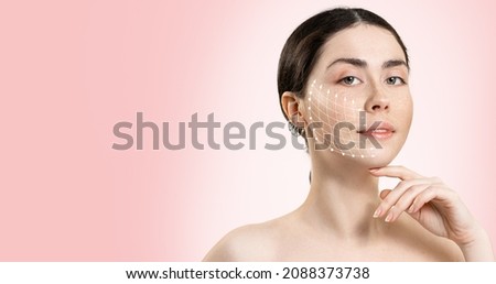 Banner of professional cosmetology. Portrait of a young beautiful woman with a mesh of thread lifting on her face. Pink background. Copy space.