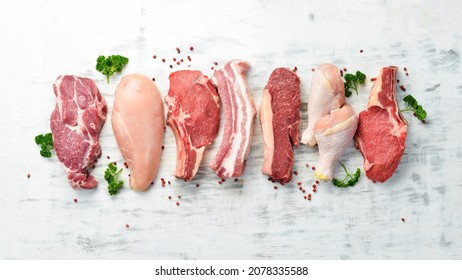 Banner. Raw meat steaks salmon, beef and chicken on a white wooden background. Organic food. Top view. - Shutterstock ID 2078335588