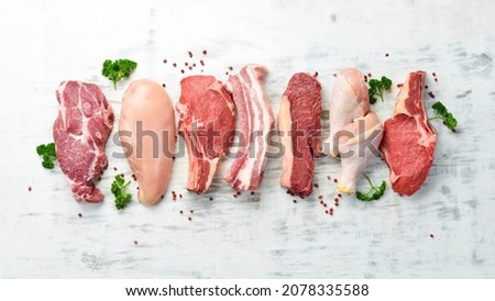 Banner. Raw meat steaks salmon, beef and chicken on a white wooden background. Organic food. Top view.
