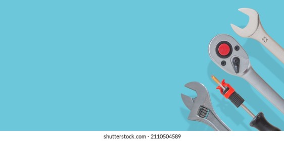 Banner with a set of workshop tools with shadows at solid turquoise background with copy space. Concept of hardware, gears, and workshop work