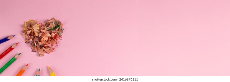 banner of sharpened colored pencils and heart-shaped pencil shavings on pastel pink color. Rainbow or LGBT pencils. Decoration for St. Valentine's Day. Top view - Powered by Shutterstock