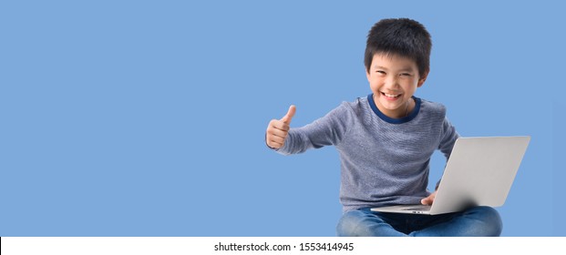 Banner Size Ratio Of Asian Little Kid With Laptop Computer Sitting On Blue Pastel Color Background, Education Learning School Concept