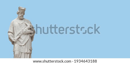 Banner with a statue of priest with figure of crucified Jesus in Vienna historical downtown at blue sky background with copy space, Austria. Concept of Cultural and Religious Heritage and Travel