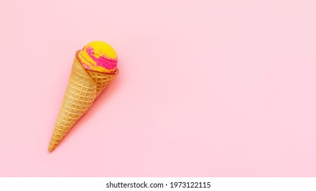 Banner. Sweet Yellow Pink Fruit Ice-cream Sorbet In A Waffle Cone With Banana And Strawberry Flavor Isolated On A Color Light Pink Background. Copy Space For Text Or Design. Summer Concept