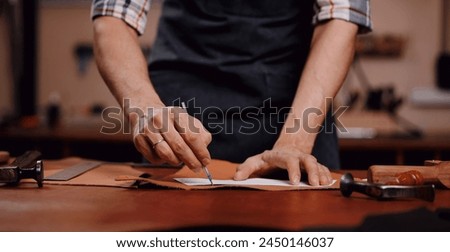 Banner tailor industry craftsman. Leather rolls and tools for handmade craft in workshop.