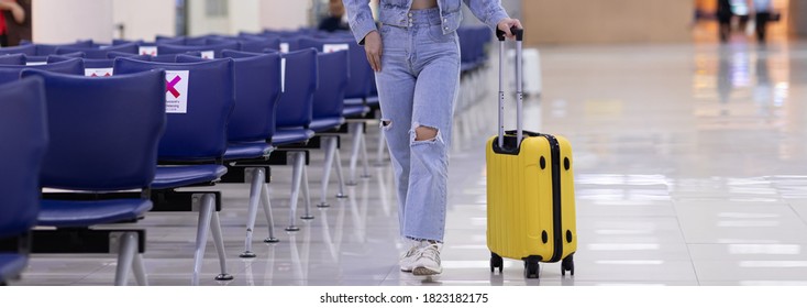 Banner of Traveller woman walking with yellow luggage at the airport - Shutterstock ID 1823182175