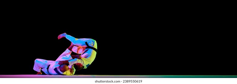 Banner. Two men Judoist training, fighting showing technical skill in neon light isolated black studio background. Concept of martial art, combat sport, health, strength, energy, fit. Copy space - Powered by Shutterstock