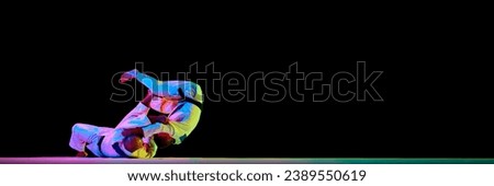 Banner. Two men Judoist training, fighting showing technical skill in neon light isolated black studio background. Concept of martial art, combat sport, health, strength, energy, fit. Copy space