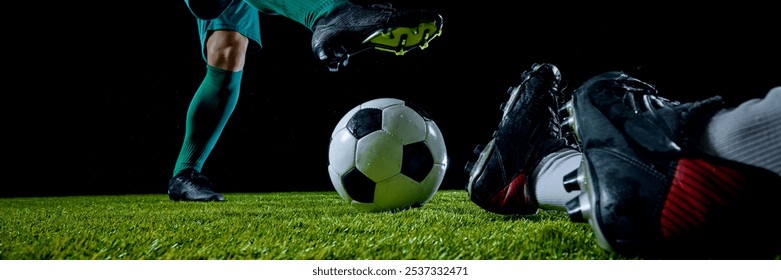 Banner. Two soccer players on grassy field competing for ball at nighttime against black studio background. Cinematic view. Concept of sport event, motion, match, championship. Ad - Powered by Shutterstock