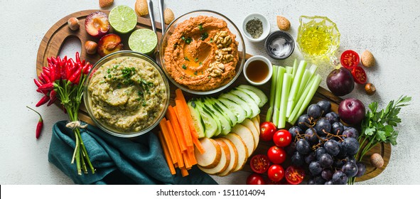 Banner Of Veggie Serving Table With Snacks With Vegetables, Fruits, Baba Ganoush And Dip Or Spread Of Roasted Red Pepper And Nuts. Healthy Vegan Food For Celebration Or Friends. Shot From Above. Copy 