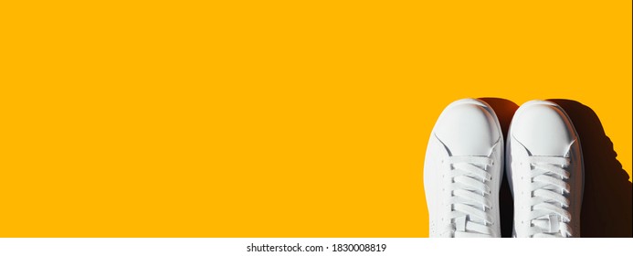 Banner With White Sneakers On An Orange Background. 