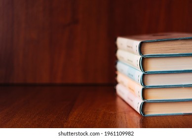 Banner with wide bookshelf and a stack of hardcovered books with bookmarks. Literature background with copy space for advertisement text - Shutterstock ID 1961109982