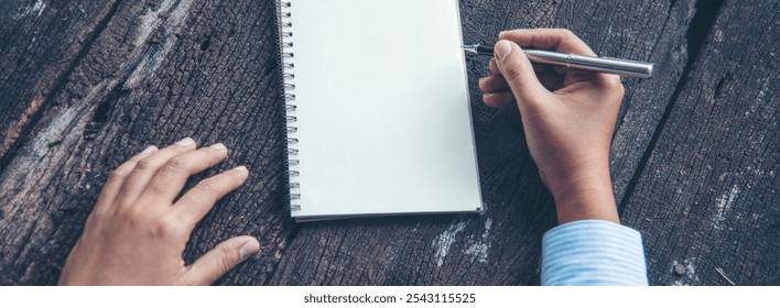 Banner Woman hands writing empty notebook planing meeting agenda on wooden table. Banner Close up women hands using pen planner organizer. Female hand holding Personal Organizer with copy space - Powered by Shutterstock