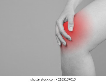 Banner With Woman Holding Painful Knee With Red Spot. Joint Pain. Sprained, Ruptured Ligaments, Meniscus Tear, Tendinitis, Arthritis. Black And White. Copy Space. High Quality Photo