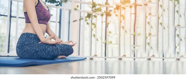 Banner Yoga fitness lifestyle healthy woman relaxation doing meditation. Yoga meditate outdoor zen sitting position. Banner Yoga woman workout sportswear sit on yoga mat home fitness with copy space - Powered by Shutterstock