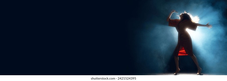 Banner. Yong artistic woman in elegant dress performing on stage against smoke and darkness. Negative space to insert text. Concept of hobby, festival, concert, disco, entertainment. Ad - Powered by Shutterstock