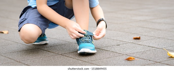 Banner Of A Young Healthy Asian Schoolboy Putting On His Running Shoes By Himself In The Playground. Life Skills, Self-care, , Comfortable Kids Shoes, Sport Day, Outdoor Fun, Get Ready Concept.