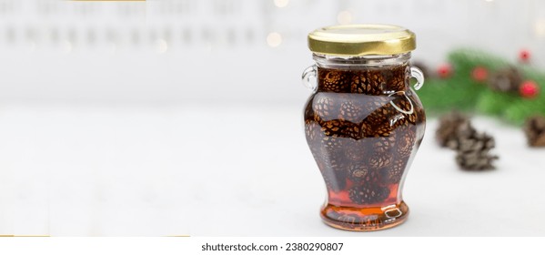 Banner with young pine cones jam in glass bowl. Delicious jam with the little pine cones.