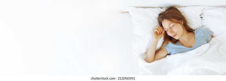 Banner of young woman enjoying sleeping time in bed , close up ,elevated view, hugging pillow.