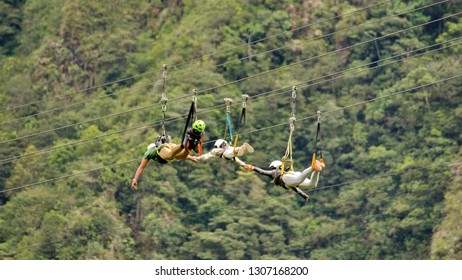 BANOS, ECUADOR - CIRCA JANUARY 2019: Family Crossing A Gorge On A Zip Line