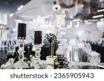 Banquet decoration composition flowers, candles, candlesticks in hall restaurant. Luxury wedding reception. Table setting, setup. Trendy black rich decor. Birthday, baptism, event. Details interior.