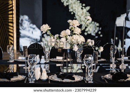 Banquet decoration composition flowers, candles, candlesticks in hall restaurant. Luxury wedding reception. Table setting, setup. Trendy black rich decor. Birthday, baptism, event. Details interior.