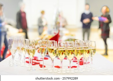 Banquet Event. Table With The Wineglasses, Snacks And Cocktails. People Celebrating In The Background.