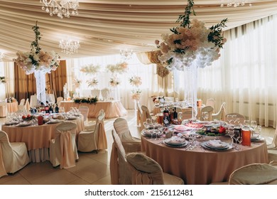 banquet hall decorated with flowers and served - Shutterstock ID 2156112481