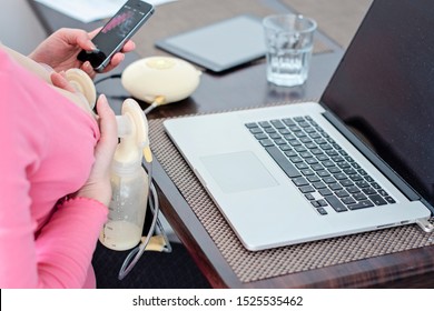 Banska Bystrica, Slovakia - January 24, 2019: Working mother concept. Breast pumping woman holding mobile phone and working on laptop at home. Home office mom. Business woman with breast pump.