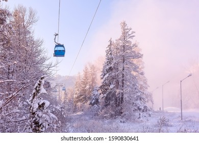 Bansko, Bulgaria pink sunset or sunrise winter resort view with ski slope in the forest, cable car cabins and mountain peaks