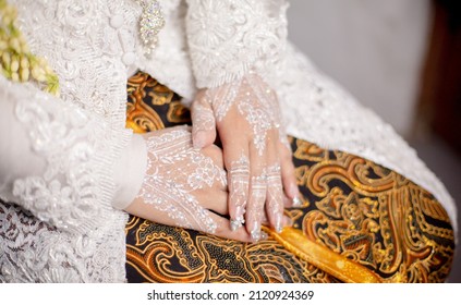 Banten, Indonesia - February 27, 2021 : wedding photo of a woman, wearing a henna in her hand and a traditional "Sundanese Indonesian" batik dress.