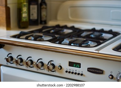 Banwell, North Somerset, UK. September 17th 2022. White And Black Rangemaster Stove Type Cooker With Burners Alight With Blue Flames. White Tiled Clean Background. Food Preparation In A Clean Setting.