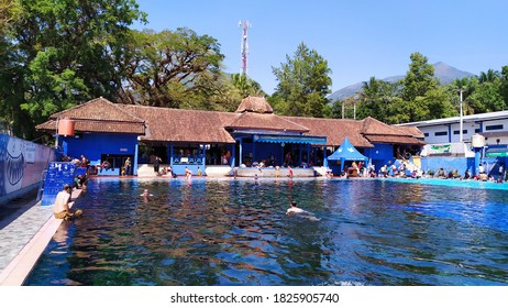 Banyubiru, Semarang, Central Java, Indonesia - July 07, 2019 : Muncul Public Swimming Pool Crowded By People To Swim Every Weekend. From Natural Spring Water. Ethnic Building With Background Trees