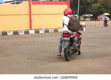 Banyumas, Indonesia - October 2, 2022 : A Photo Of An Unknown Male High School Student Riding A Motorcycle After Coming Home From School