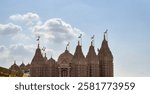 The BAPS Hindu Mandir in Abu Dhabi, with its intricately carved sandstone shikhars and golden spires, stands as a spiritual and architectural masterpiece reflecting Hindu culture and devotion.