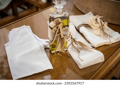 Baptism Ceremony Essentials: Elegant Set with Decorated Oil Bottle and White Underwear Ensemble. Ideal for use in religious ceremonies, cultural events, and editorial features. Selective focus.