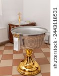 Baptism font with water with towel in an Orthodox church. The interior of the room for infant baptism in the Orthodox Church.