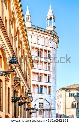 The baptistery of Parma in Piazza Duomo seen from the street with typical yellow buildings, in Parma historical center, Emilia Romagna region, Italy. 