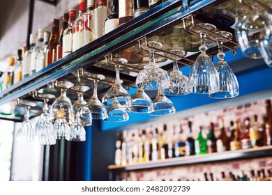Bar, alcohol bottle and upside down glasses in restaurant for cocktail, wine or whiskey. Pub, drink and glassware hanging at club room interior for champagne with luxury design at hotel on background - Powered by Shutterstock