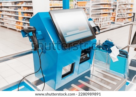 bar code scanner at the self service checkout in modern supermarket. Cashier replaced by automated machine, job loss concept