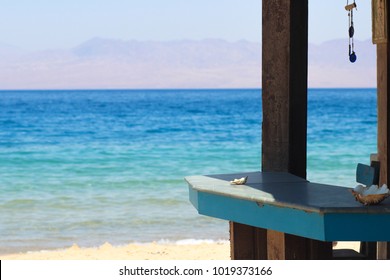 Bar Counter At Beach & Azure Turquoise Sea With Mountains Background 