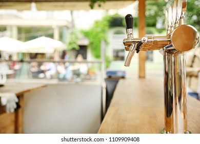 Bar counter with draft beer taps in open-air cafe
