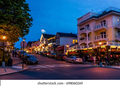 Bar Harbor, USA - June 8, 2017: People Walking Sidewalk Street By Main Road In Downtown Village During Evening Night