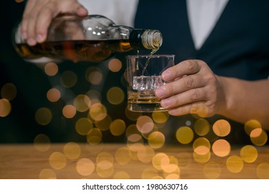 Bar Man Pouring Whiskey Glass On Beautiful Bokeh Background  