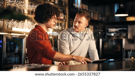 Bar, manager and training with tech for order, teamwork and explaining system to employee and night. Pub, server and people with app to process transactions, working late or help with sales data