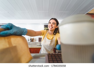 Bar Owner Working Only With Take Away Orders During Corona Virus Outbreak - Young Woman Worker Wearing Surgical Gloves Giving Takeout Meal To Customers - Healthcare And Food Drink Concept