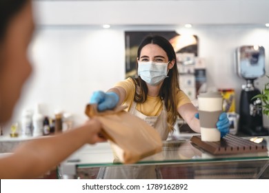 Bar owner working only with take away orders during corona virus outbreak - Young woman worker wearing face surgical mask giving takeout meal to customers - Healthcare and Food drink concept  - Shutterstock ID 1789162892
