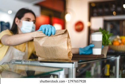 Bar Owner Working Only With Take Away Orders During Corona Virus Outbreak - Young Woman Worker Wearing Face Surgical Mask Giving Takeout Meal To Customers - Healthcare And Food Drink Concept 