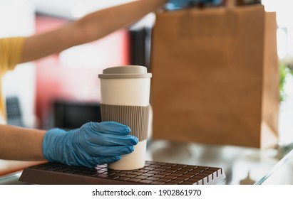 Bar Owner Working Only With Take Away Orders During Corona Virus Outbreak - Young Woman Worker Wearing Surgical Gloves Giving Takeout Meal And Coffee To Customers - Healthcare And Food Drink Concept