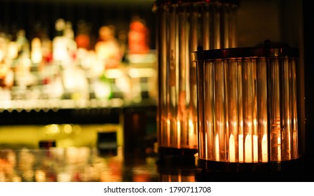 A bar scene a decorative lamp and in the background lots of liquor bottles at the bar counter and its reflection on the counter. - Powered by Shutterstock - Get 15% off with code: PIKWIZARD15